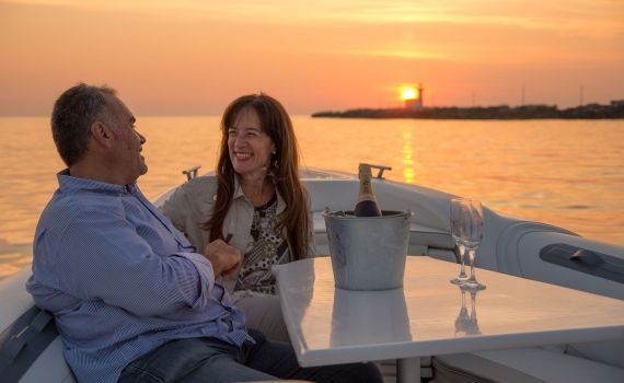 Una coppia a bordo di un'imbarcazione durante l'aperitivo al tramonto a Trapani