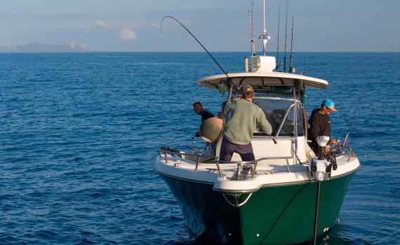 Uomini con una canna da pesca su una barca noleggiata per pescare